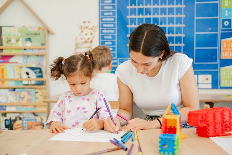 An educational psychologist supporting a young child with a classroom activity